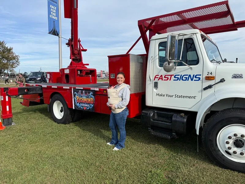 An image of Morgan in front of a FASTSIGNS installation truck.